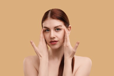 Photo of Portrait of beautiful woman with freckles on beige background