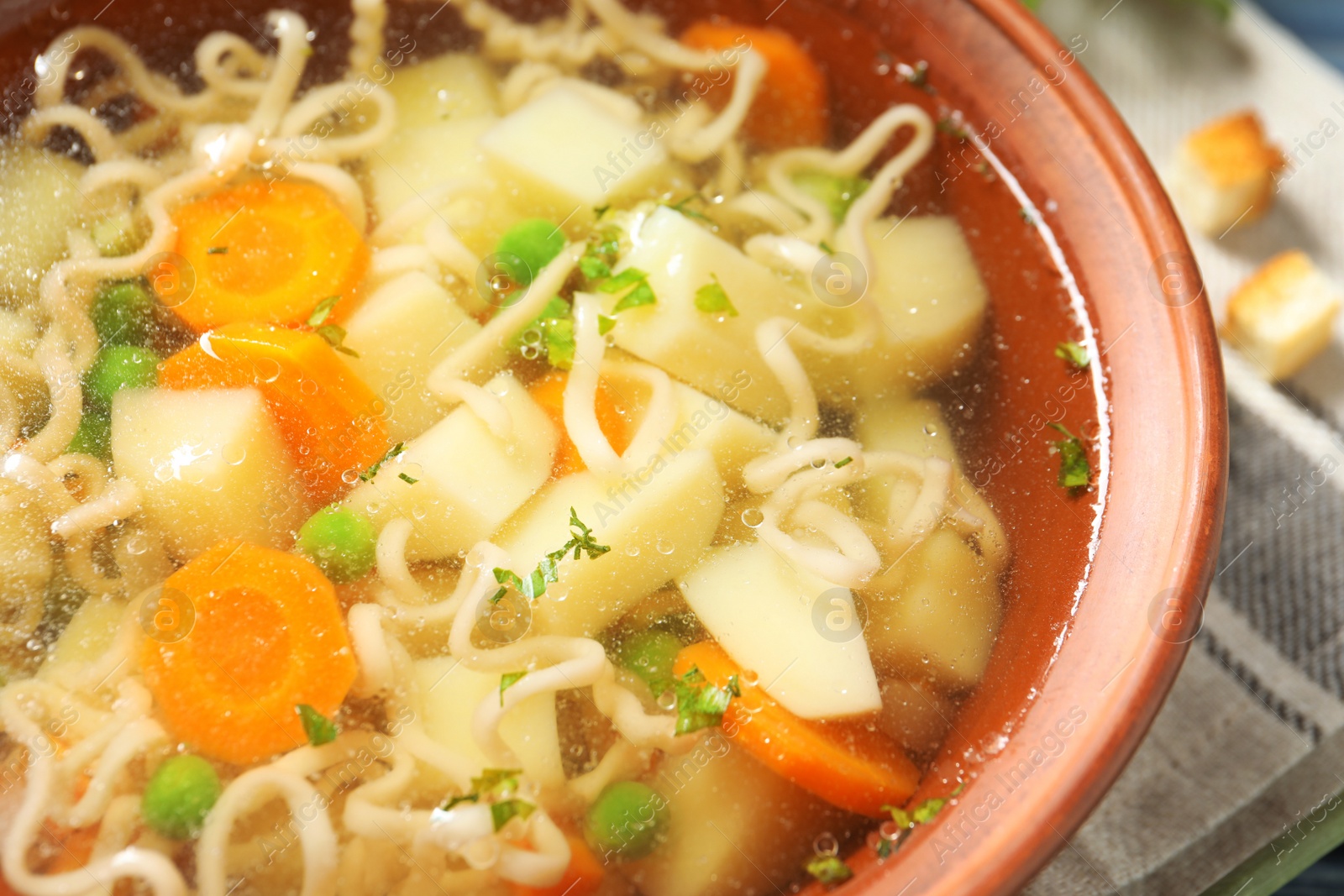 Photo of Bowl of fresh homemade vegetable soup on table, closeup