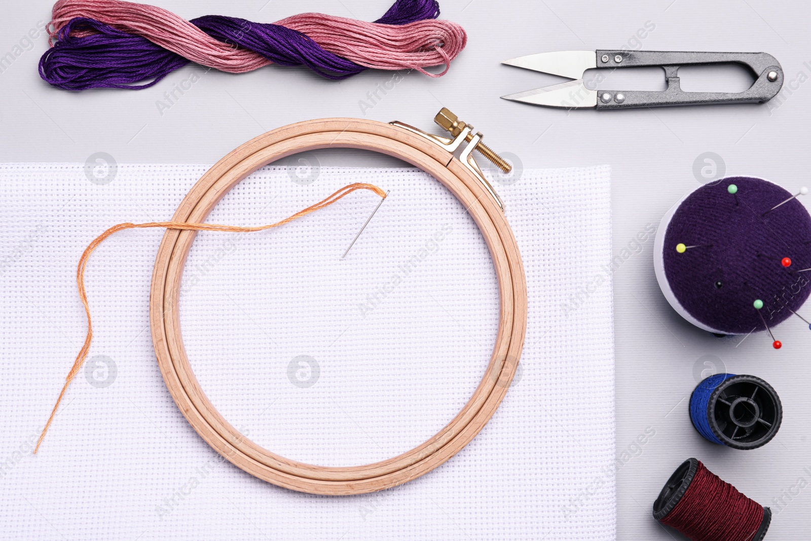 Photo of Set of embroidery equipment on light grey background, flat lay