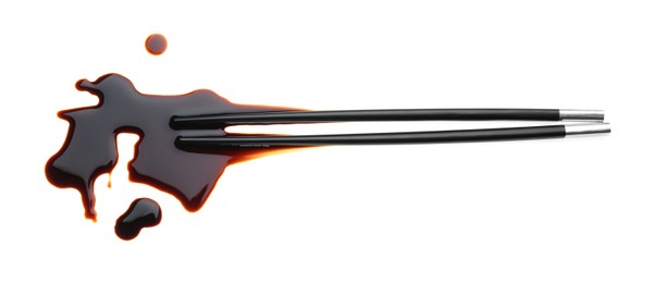 Spilled soy sauce with chopsticks on white background, top view