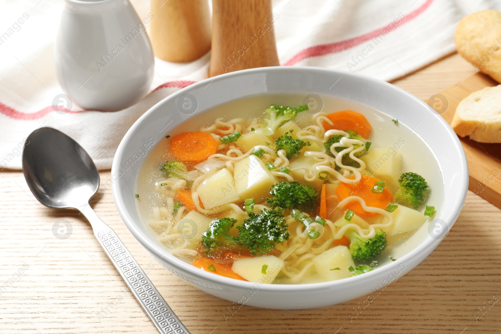 Photo of Bowl of fresh homemade vegetable soup served on wooden table