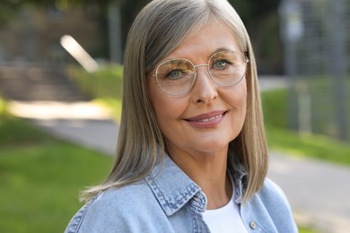 Photo of Portrait of beautiful senior woman in glasses outdoors