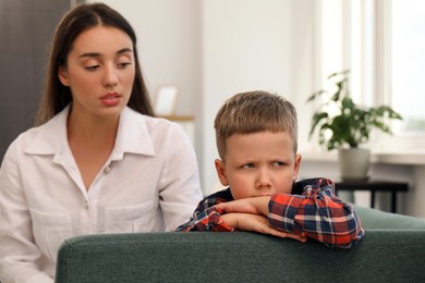 Photo of Psychologist working with unhappy little boy in office. Mental health problems