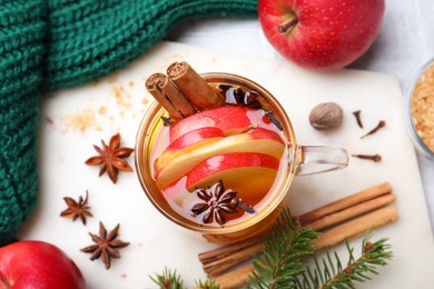 Photo of Aromatic hot mulled cider on light table, flat lay