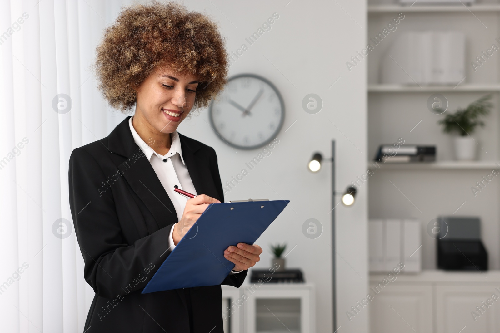 Photo of Happy notary with clipboard writing notes in office