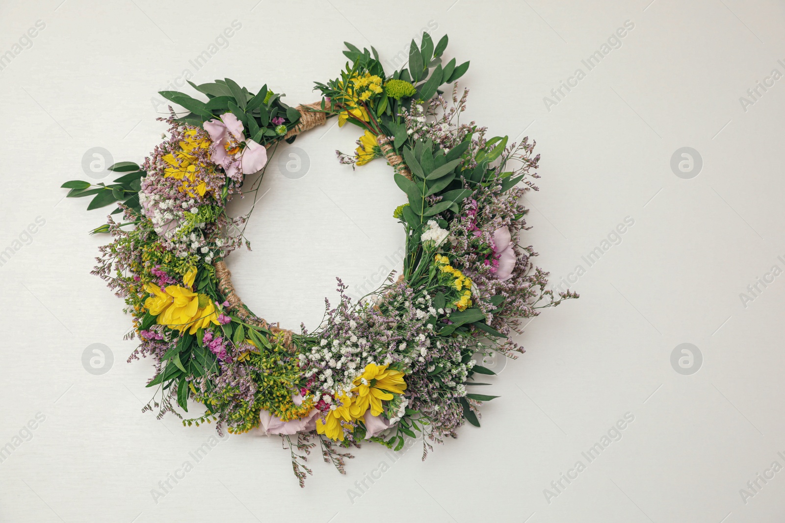 Photo of Wreath made of beautiful flowers on white background, top view