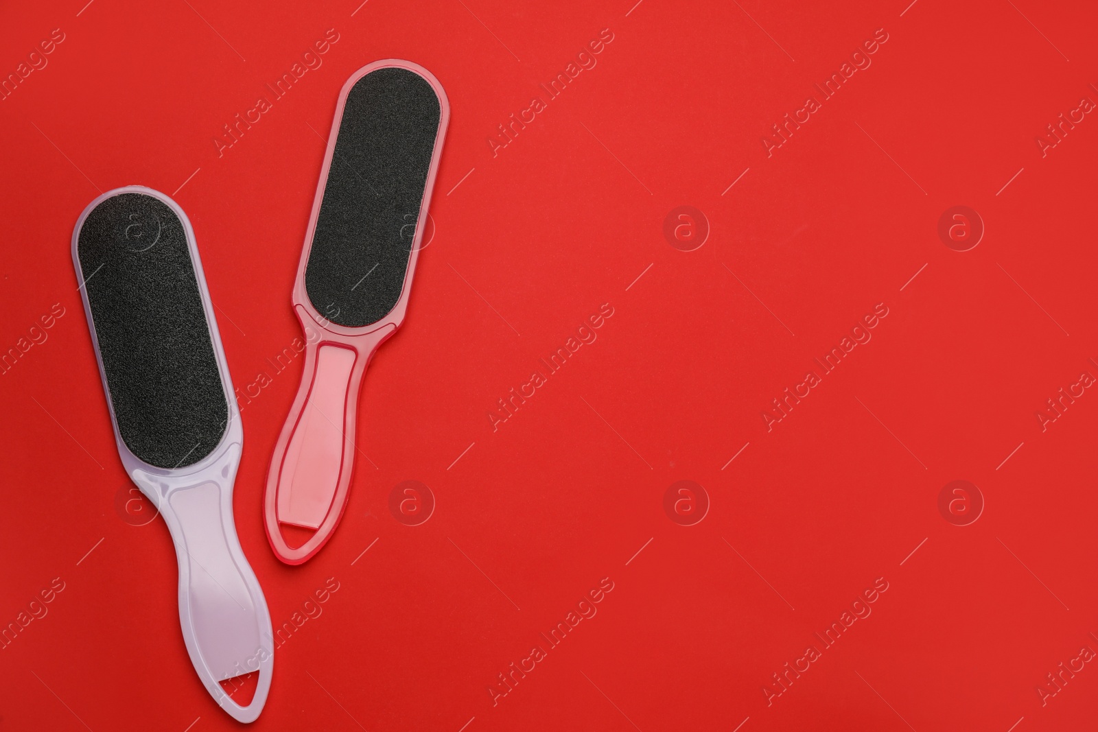 Photo of Foot files on red background, flat lay with space for text. Pedicure tools