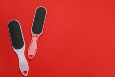 Foot files on red background, flat lay with space for text. Pedicure tools