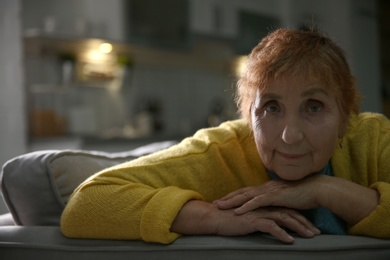 Portrait of elderly woman on sofa at home