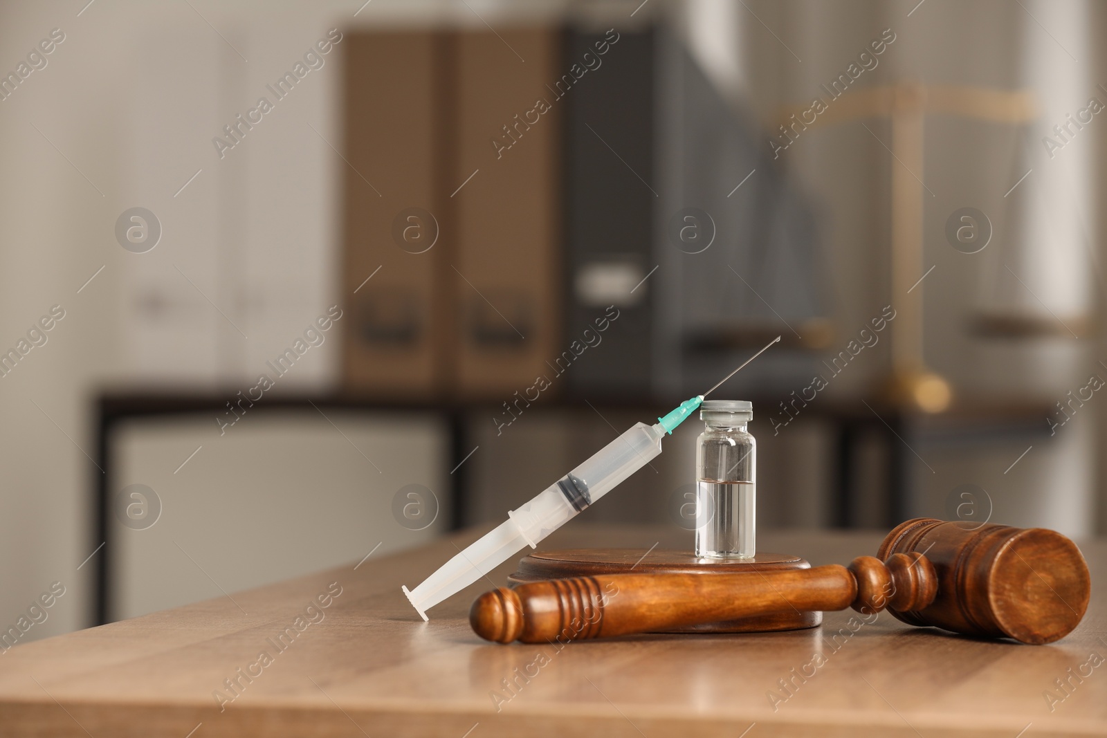 Photo of Law concept. Gavel, syringe and glass vial on wooden table, space for text