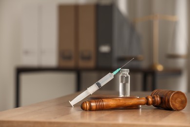 Photo of Law concept. Gavel, syringe and glass vial on wooden table, space for text