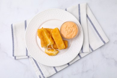 Photo of Plate with tasty fried mozzarella sticks and sauce on white marble table, top view