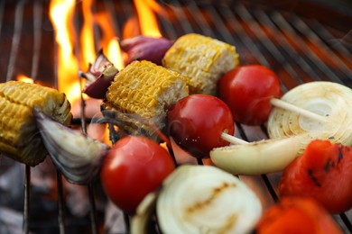 Skewers with delicious grilled vegetables on barbecue grill, closeup
