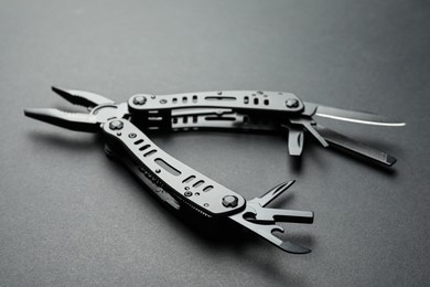 Compact portable multitool on black background, closeup