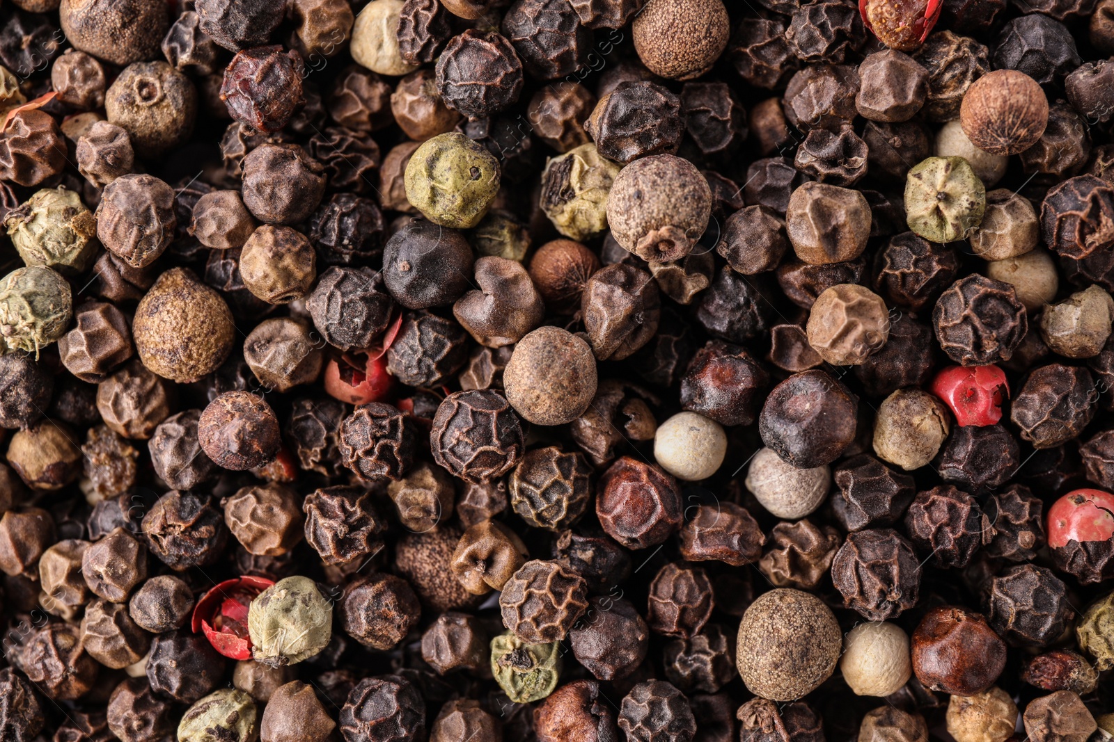 Photo of Pepper grains mix as background, top view