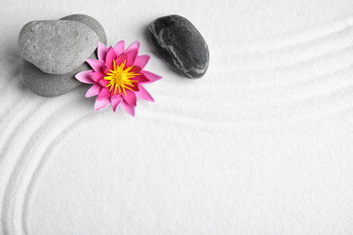 Zen garden. Beautiful lotus flower, stones and space for text on white sand, flat lay