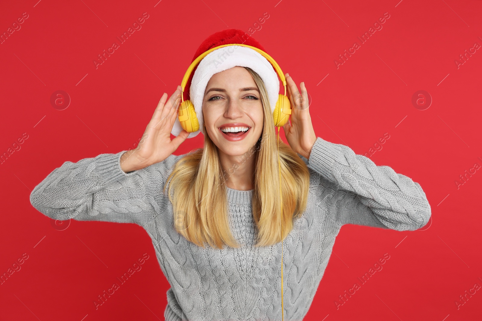 Photo of Happy woman with headphones on red background. Christmas music