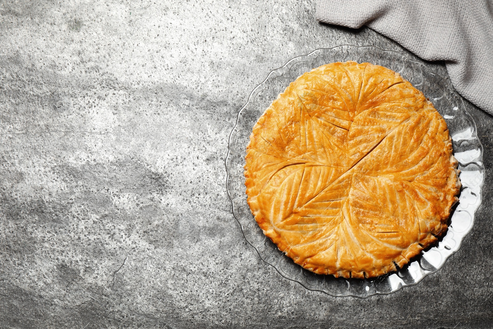 Photo of Traditional galette des rois on grey table, top view. Space for text