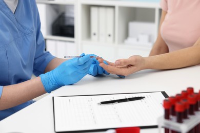 Photo of Laboratory testing. Doctor taking blood sample from patient at white table in hospital, closeup