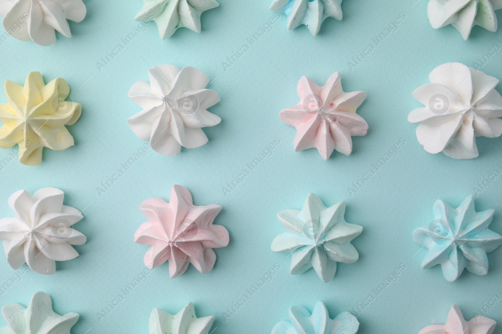 Photo of Delicious meringue cookies on light blue background, flat lay