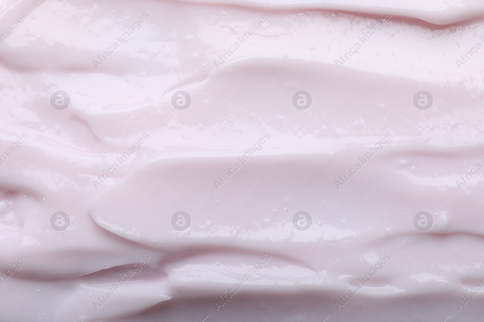 Photo of Closeup view of light pink body cream as background