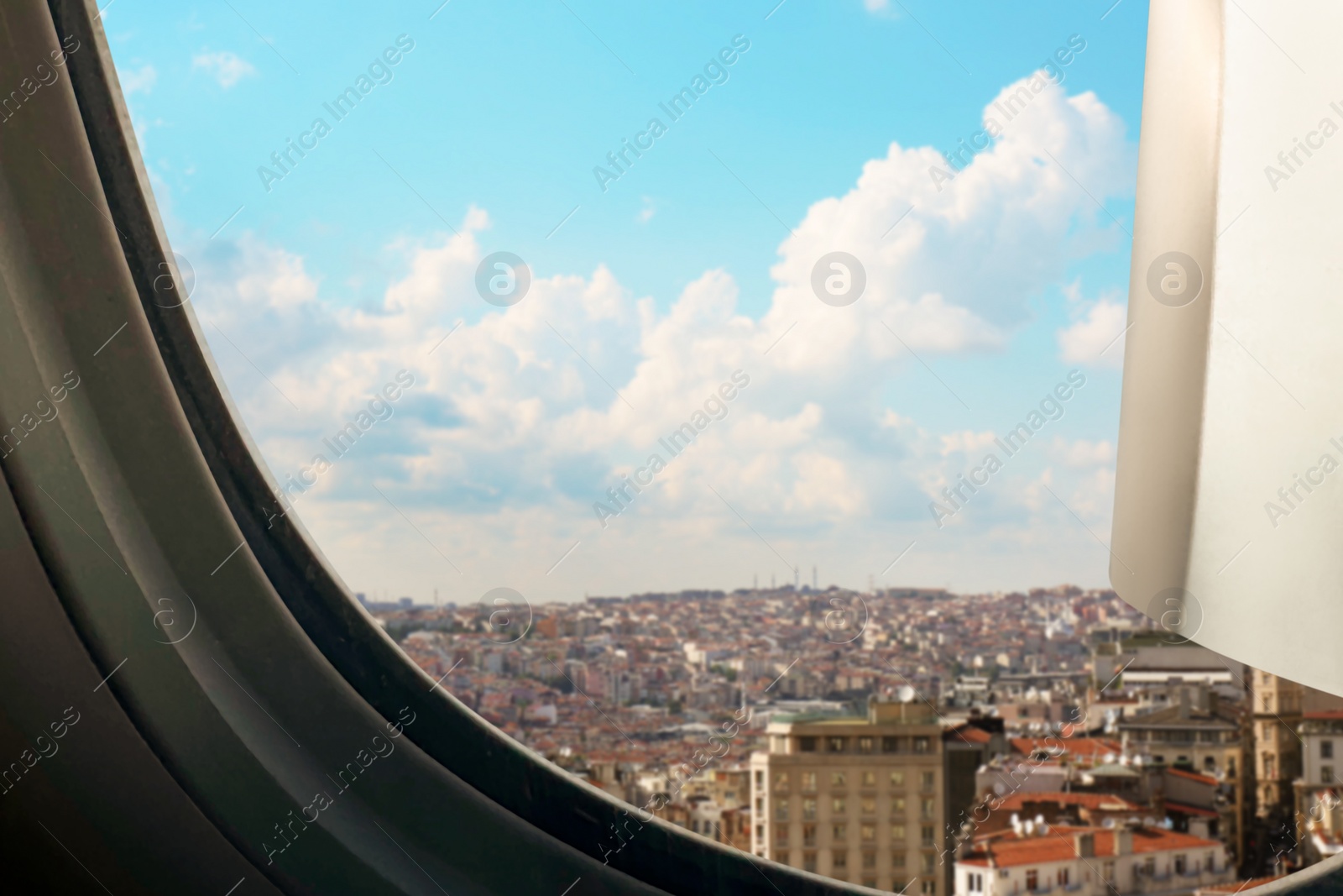 Image of Beautiful city with buildings, view through airplane window during flight