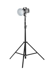 Studio flash light on tripod against white background. Professional photographer's equipment