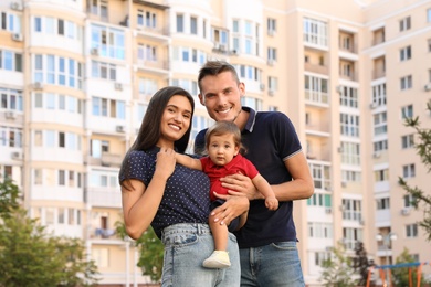 Photo of Happy family with adorable little baby outdoors