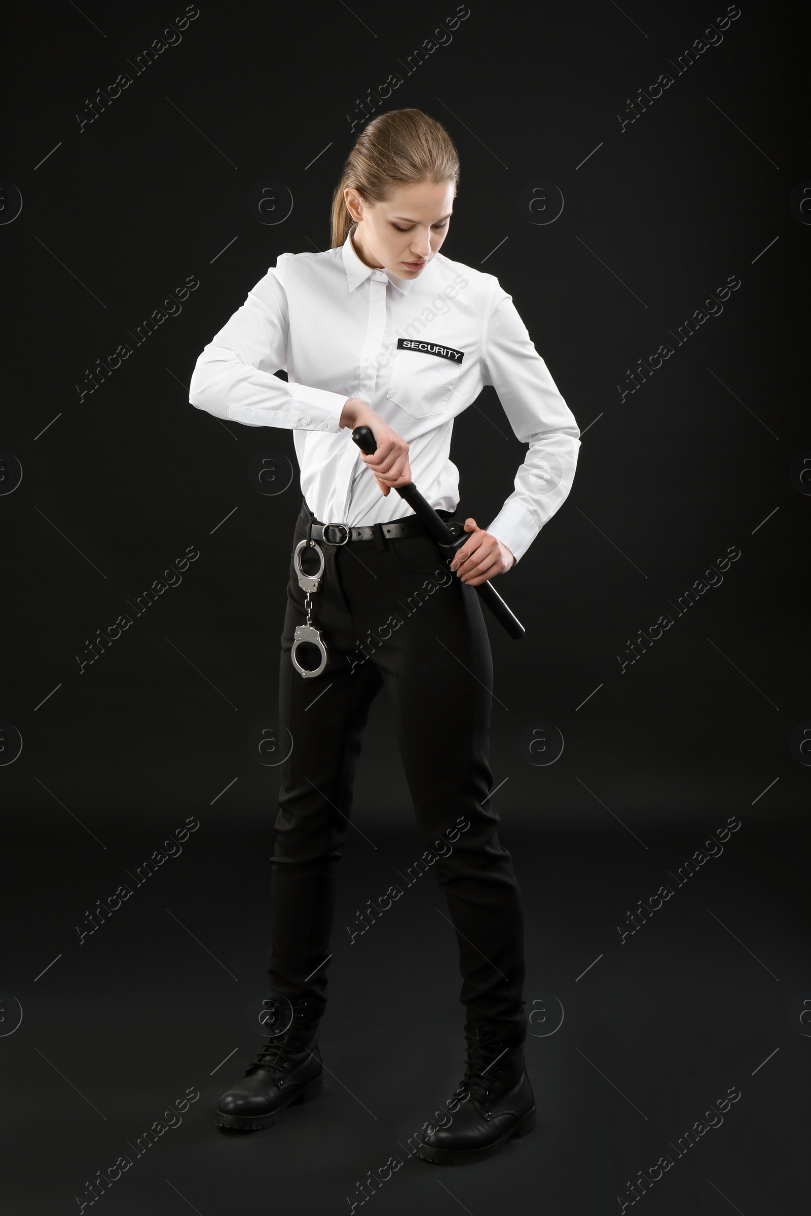 Photo of Female security guard with police baton on dark background