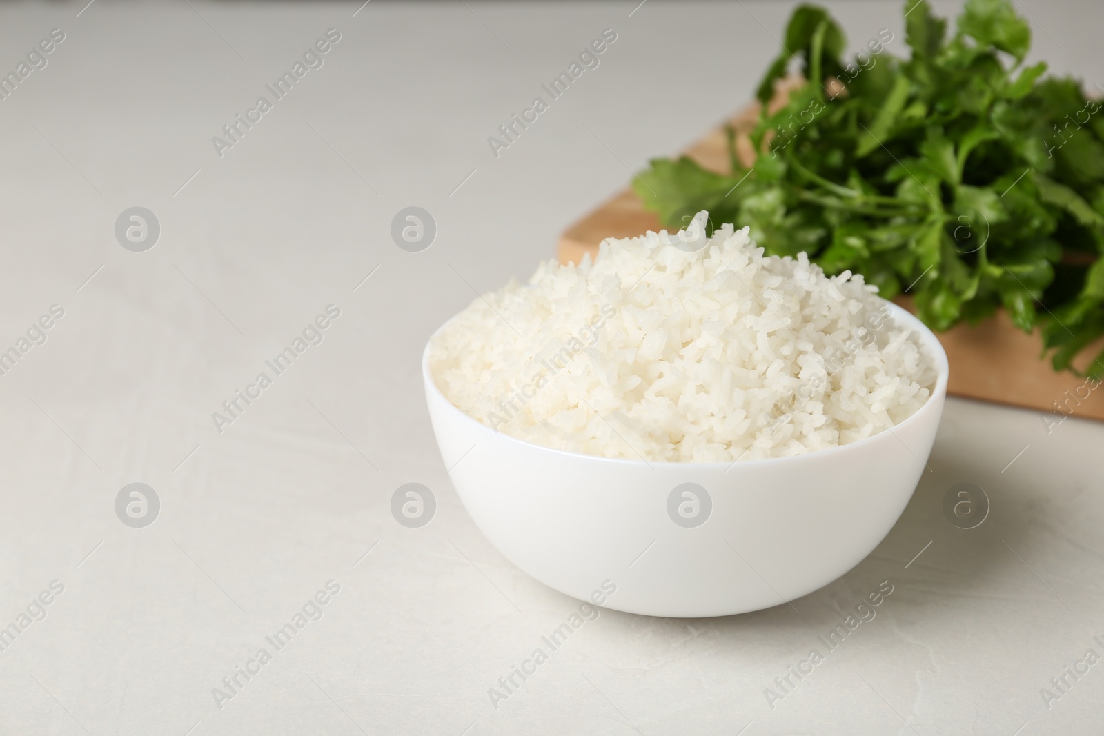 Photo of Bowl of boiled rice on light table. Space for text