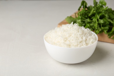 Photo of Bowl of boiled rice on light table. Space for text