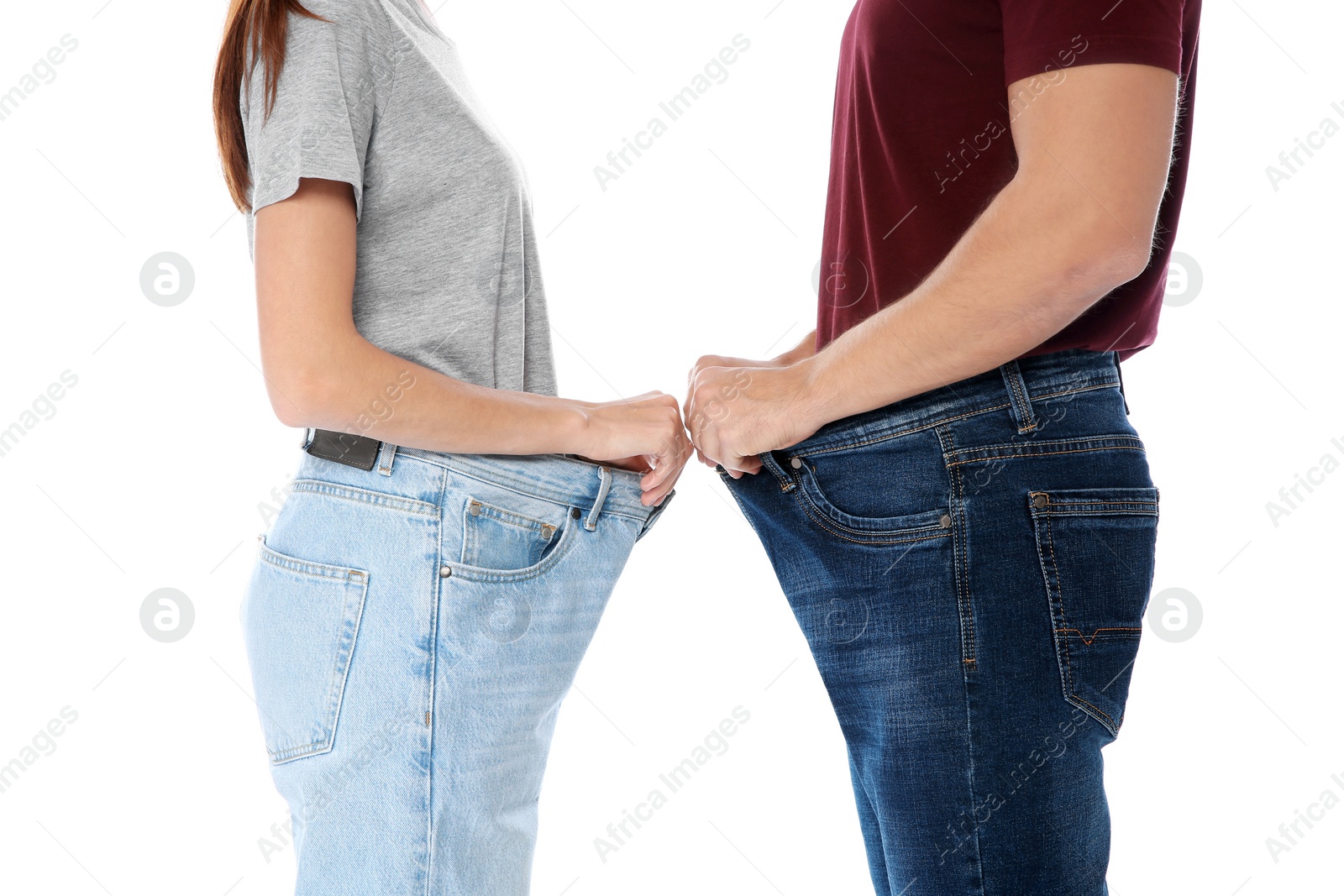 Photo of Fit people in oversized jeans on white background, closeup. Weight loss