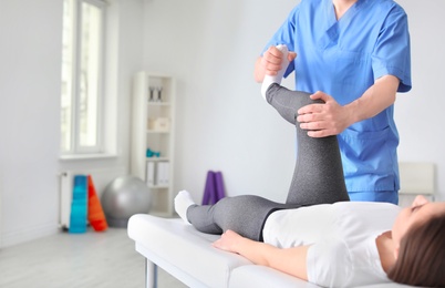 Physiotherapist working with female patient in clinic