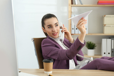 Photo of Lazy employee playing with paper plane in office