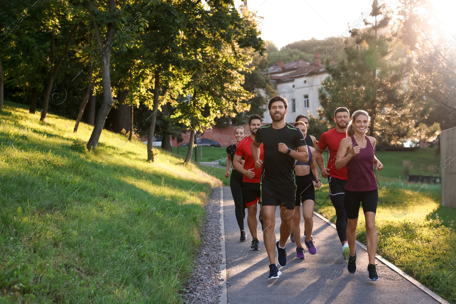 Photo of Group of people running outdoors on sunny day. Space for text