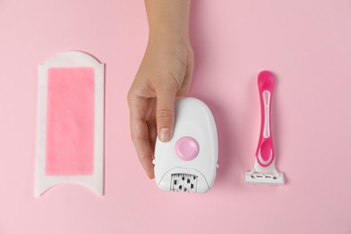 Woman with different epilation products on pink background, top view