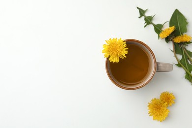 Photo of Delicious fresh tea and beautiful dandelion flowers on white background, top view. Space for text