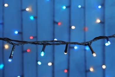 Beautiful Christmas lights on color background, closeup