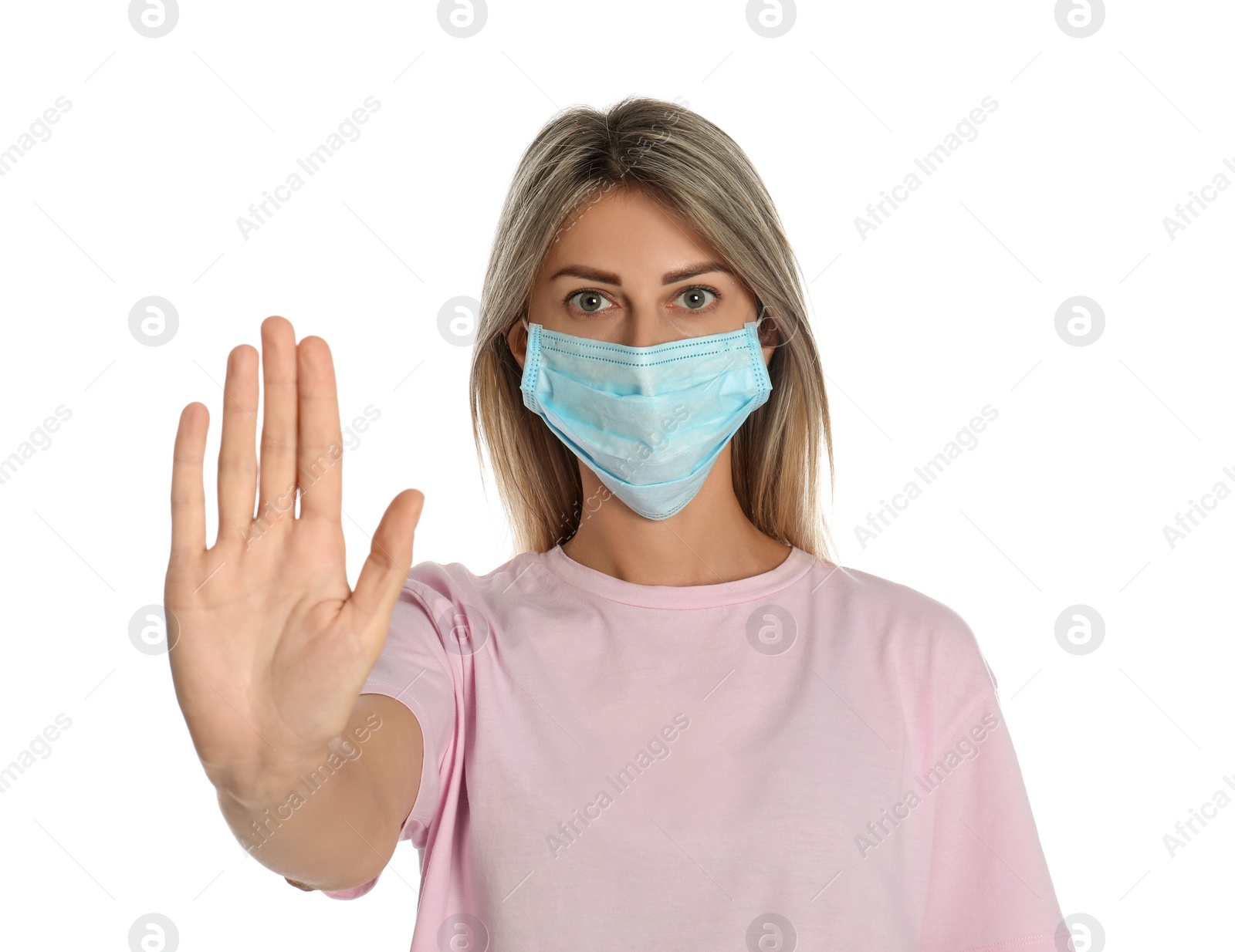 Photo of Woman in protective mask showing stop gesture on white background. Prevent spreading of coronavirus