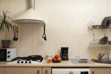 Photo of Stylish kitchen interior with different modern appliances and apples