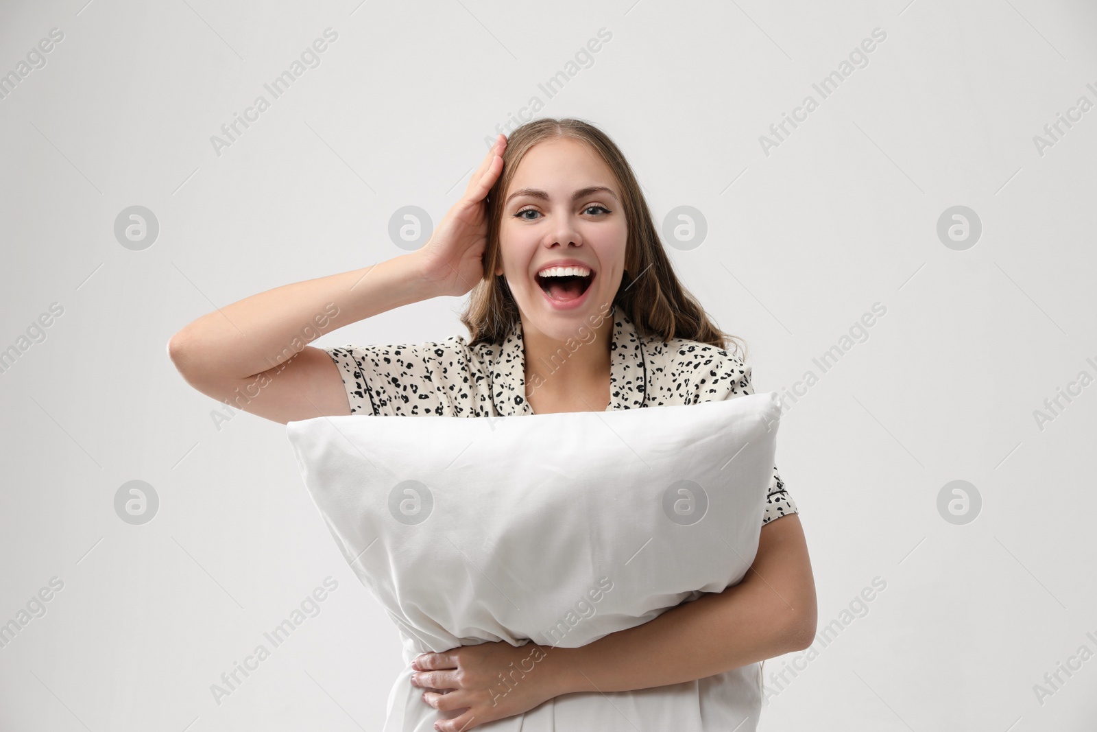 Photo of Beautiful woman with pillow on light grey background. Bedtime