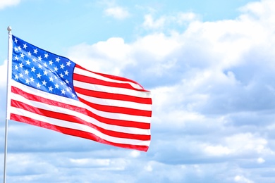 Photo of American flag outdoors on cloudy day. Space for text