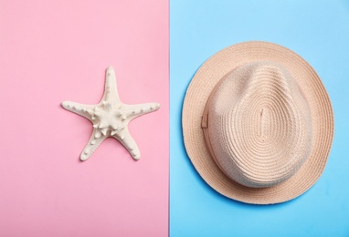 Photo of Stylish hat and sea star on color background, top view. Beach resort