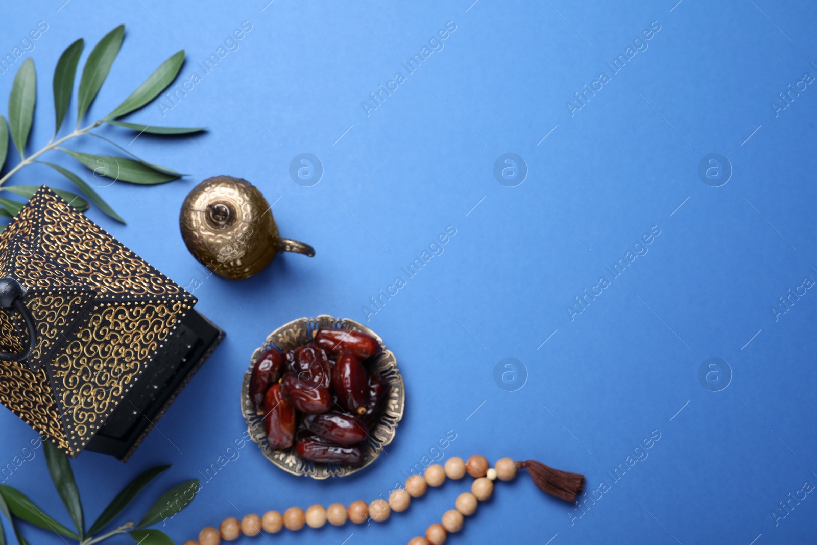 Photo of Flat lay composition with Arabic lantern on blue background. Space for text