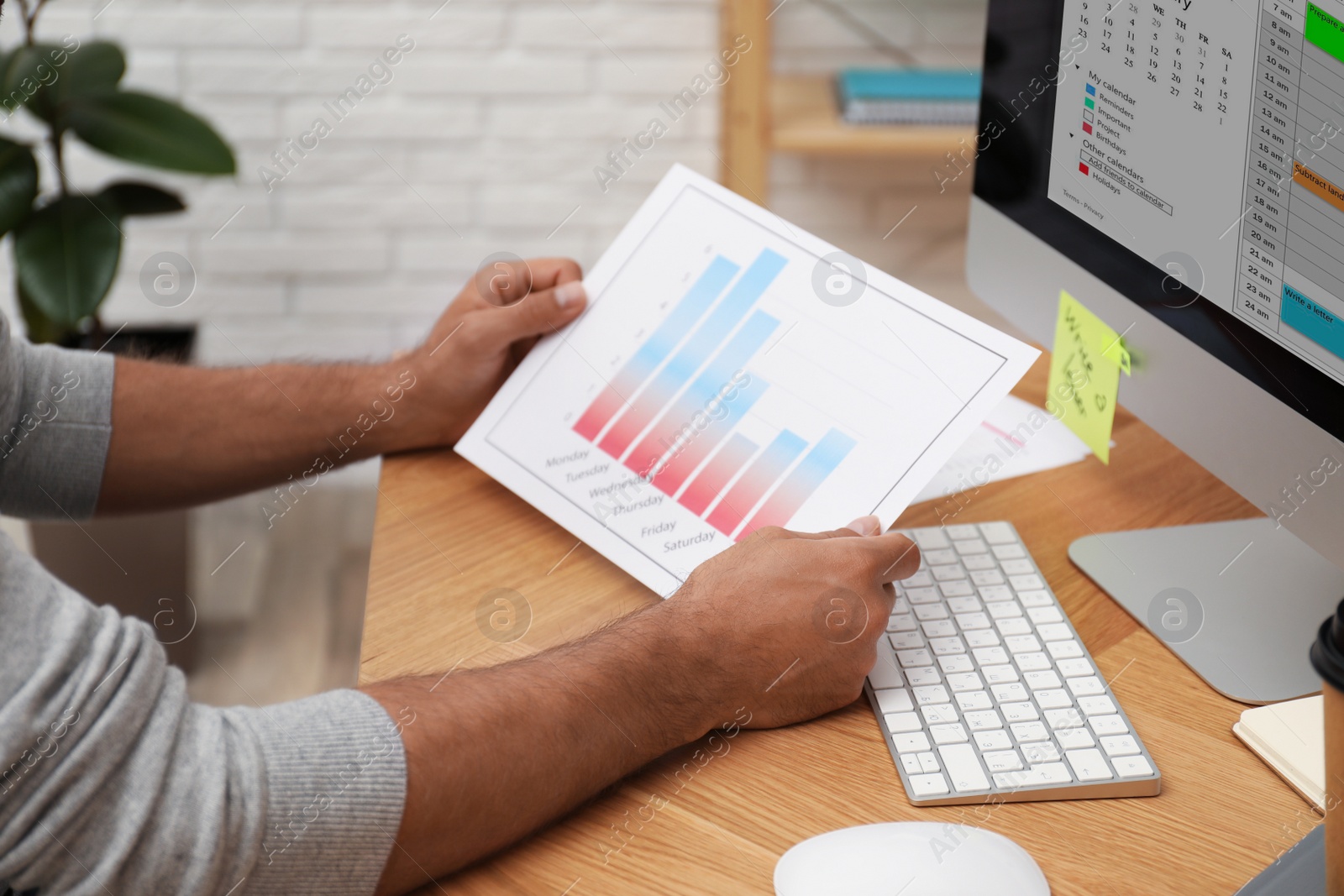 Photo of Man working with calendar at table in office, closeup