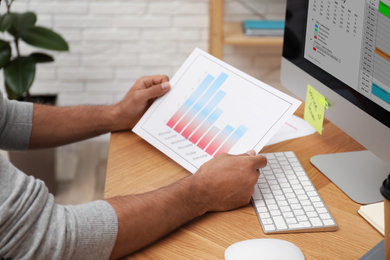 Man working with calendar at table in office, closeup