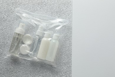 Cosmetic travel kit in plastic bag on color background, top view and space for text. Bath accessories