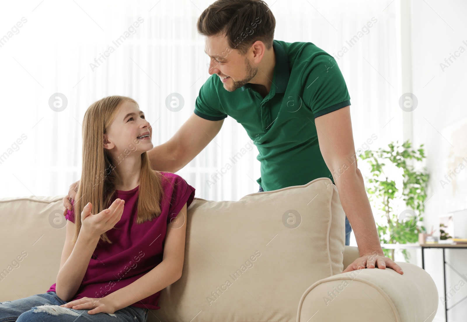 Photo of Father talking with his teenager daughter at home