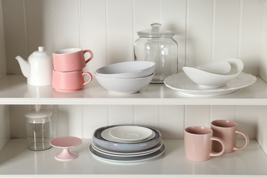 Photo of Stylish storage stand with different ceramic dishware at home