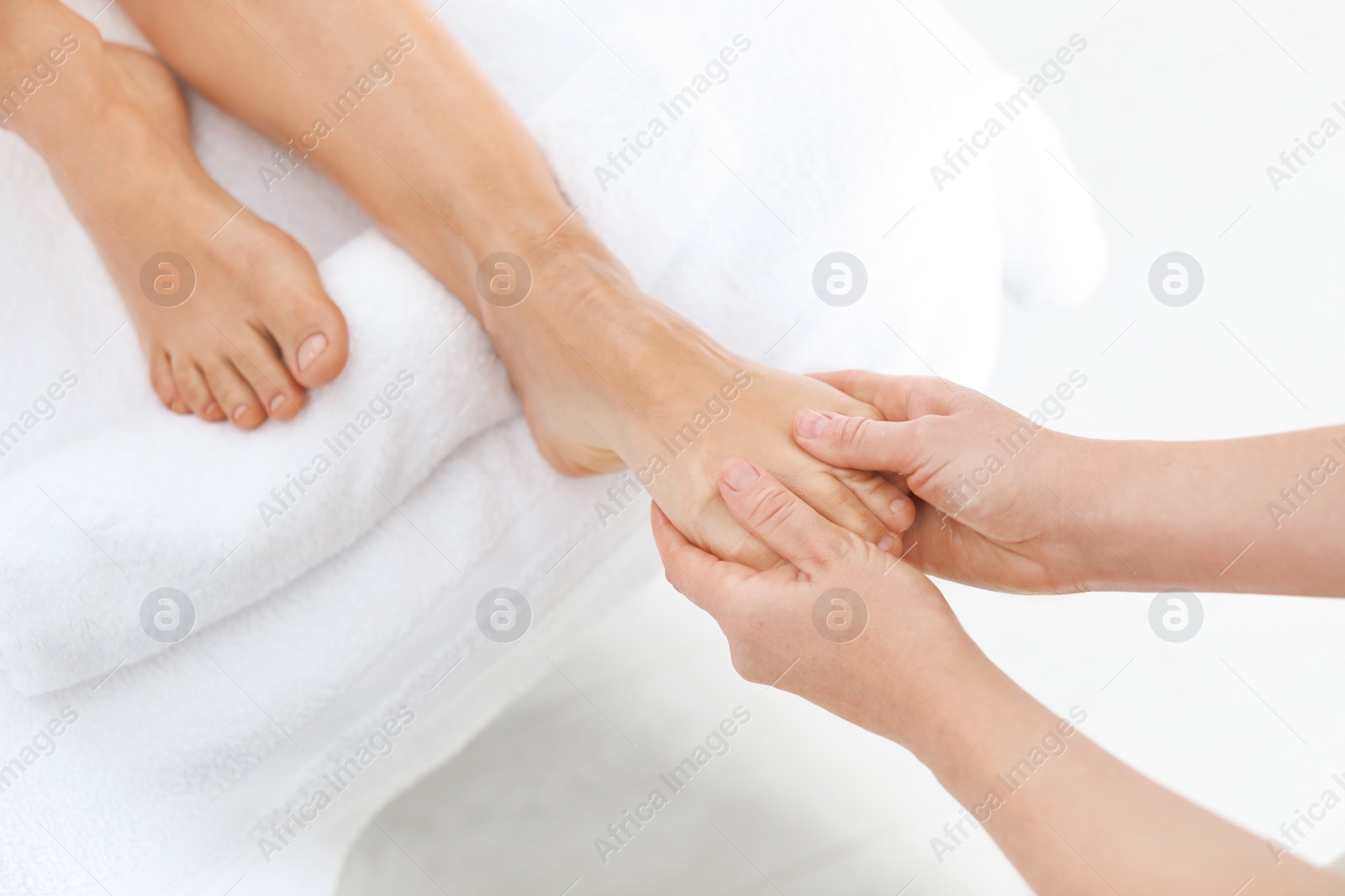 Photo of Woman receiving foot massage in wellness center, closeup